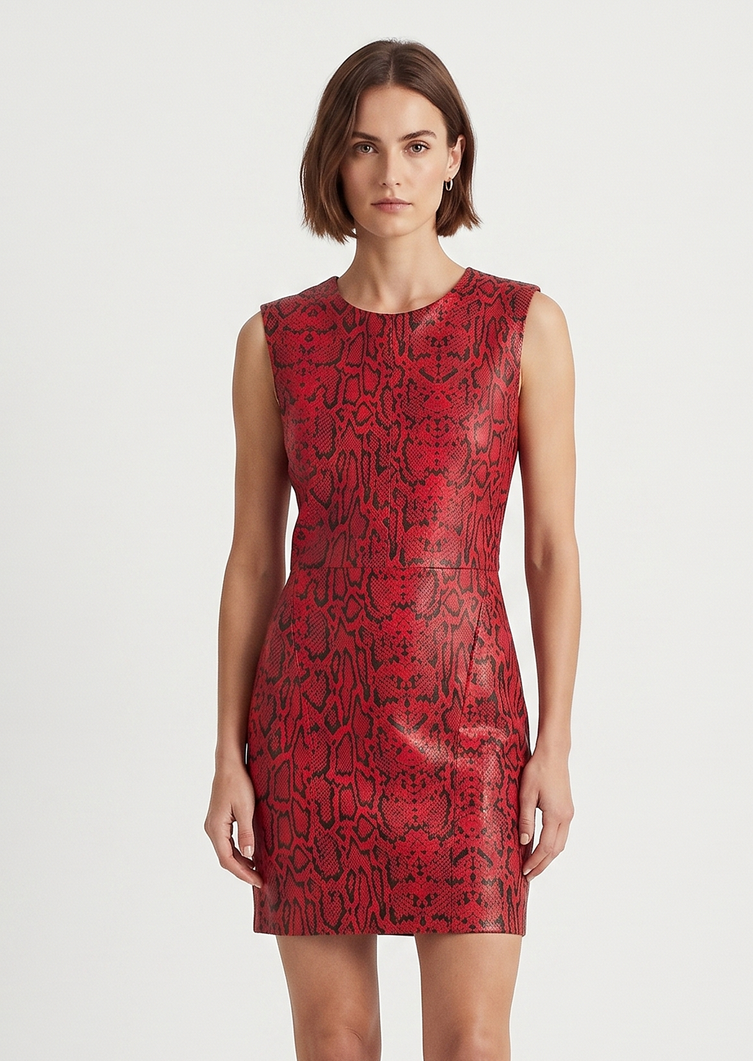 A woman modeling a sleeveless red mini dress with a black abstract pattern, paired with black high heels, against a plain light gray studio background.